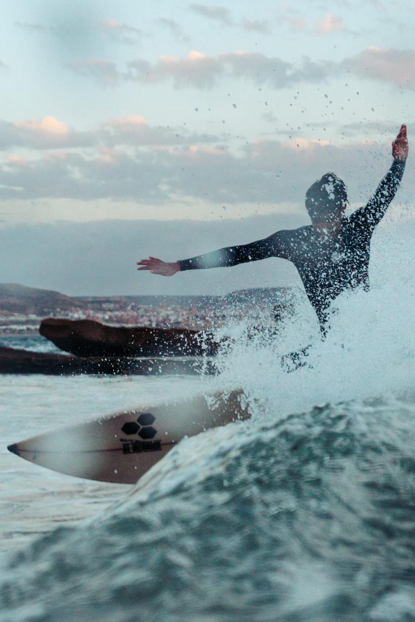Surfer moving through the spray of a breaking wave